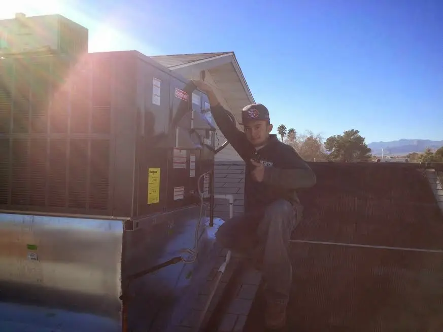 HVAC technician performing AC Tune-Up on a rooftop unit in La Crosse